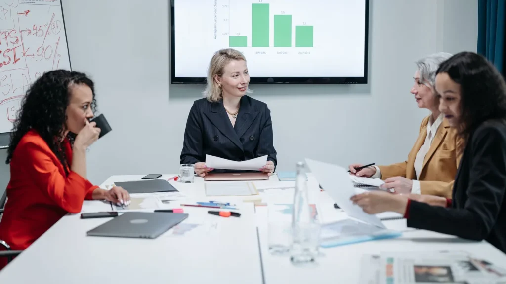 Profesionales en una reunión comercial analizando una propuesta y gráficos