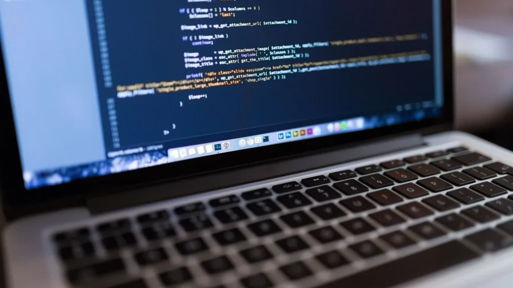 Portátil mostrando código y una web en proceso de desarrollo
